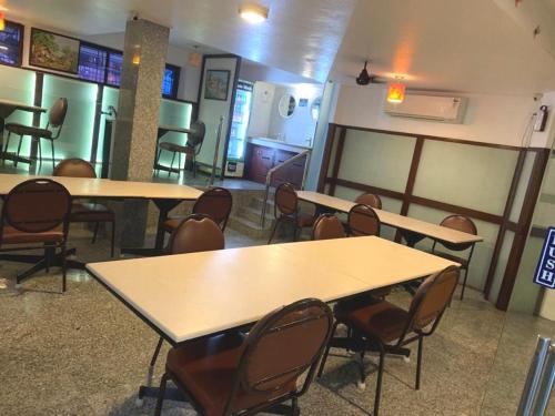 a room with tables and chairs in a restaurant at Pondicherry Executive Inn in Puducherry