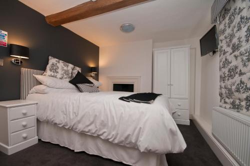 a bedroom with a white bed and a fireplace at The Vernon in Droitwich