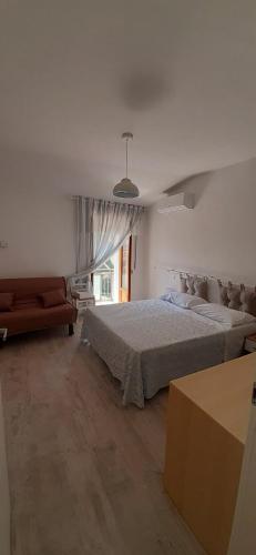 ein Schlafzimmer mit einem großen Bett und einem Sofa in der Unterkunft B&B Belvedere Castelluccio Valmaggiore in Castelluccio Valmaggiore