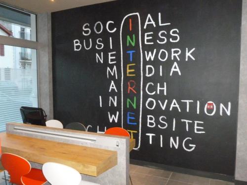 a meeting room with a black wall with white writing on it at ibis Bayonne Centre in Bayonne