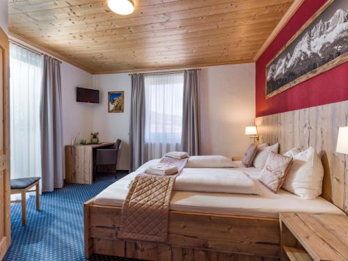 a hotel room with a large bed and a desk at Haus Tirol in Brixen im Thale