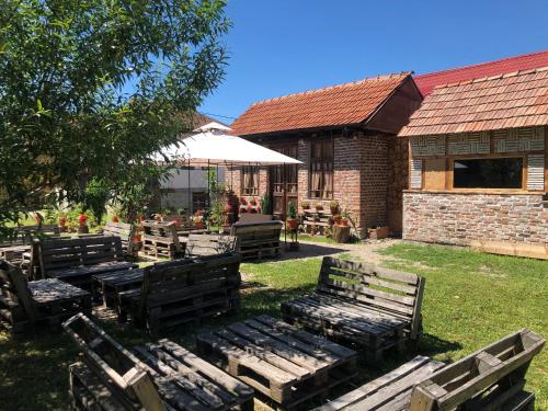 a group of wooden benches in front of a building at Old Court in Curtea de Argeş