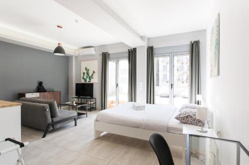 - une chambre avec un lit et un salon dans l'établissement Omnia Pagrati Apartments, à Athènes