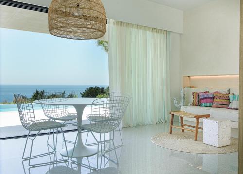 a living room with a table and chairs and a bed at Mimi and Coco Villas Corfu in Paramonas