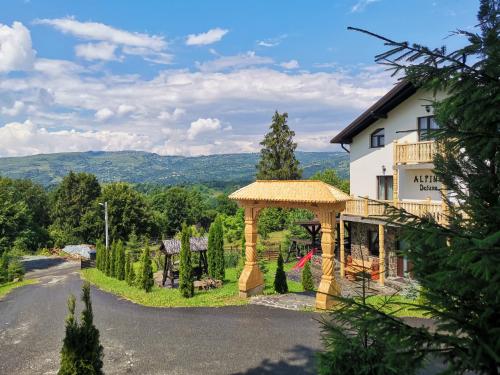 a house with a gazebo next to a road at Alpina Panoramic in Moisei