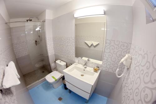 a white bathroom with a sink and a toilet at Apartamente Liliacul in Jupiter
