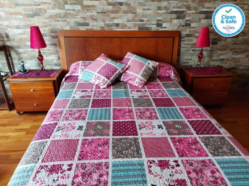 een bed met een dekbed in een slaapkamer bij Nelocas House in Ponta Delgada