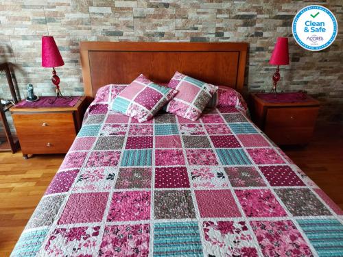 Una cama con edredón en un dormitorio en Nelocas House, en Ponta Delgada
