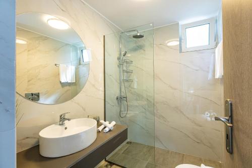 a bathroom with a sink and a glass shower at MariAndry Villa, Secluded Retreat with Pool, BBQ & HotTub, By ThinkVilla in Episkopí- Rethimno