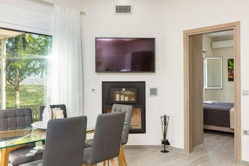 a dining room with a table and a fireplace at MariAndry Villa, Secluded Retreat with Pool, BBQ & HotTub, By ThinkVilla in Episkopí- Rethimno