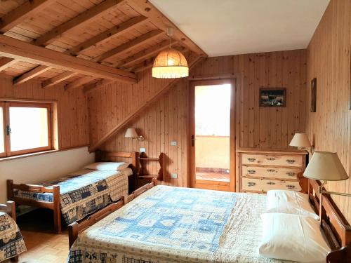 a bedroom with two beds in a room with wooden walls at Residence Mirage in Oga