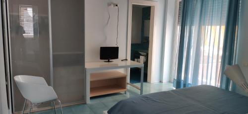 a bedroom with a bed and a desk with a television at Rock Garden in Gaeta