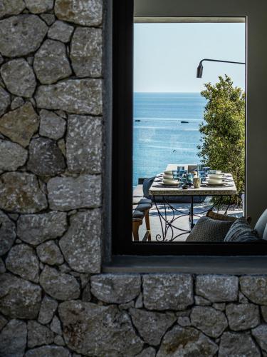 a window view of a table with a view of the ocean at Mimi and Coco Villas Corfu in Paramonas
