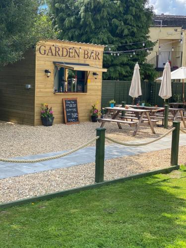 a garden bar with tables and umbrellas at Greyhound Country Inn in Honiton