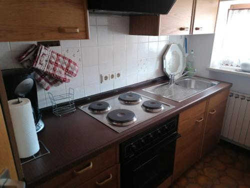 a kitchen with a stove top oven next to a sink at FeWo Steckenbergblick/Gästecard in Unterammergau