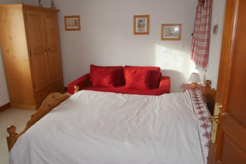 a bedroom with a large bed with red pillows at gite joseph 2pers dans le vignoble à 8km de Colmar in Ammerschwihr