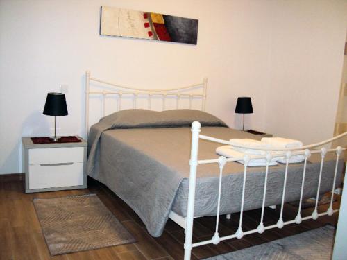 a bedroom with a white bed with two night stands and two lamps at Alojamento Rodrigues in Arcos de Valdevez