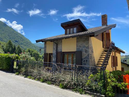 a small house with a fence next to a road at Mansarda Villa Simonetta in Esino Lario