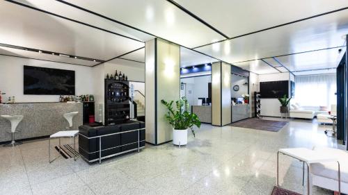 a large room with a lobby with a table and chairs at Hotel Lis in Asti