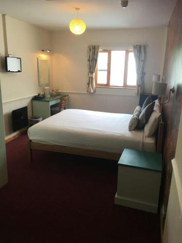 a bedroom with a large bed and a window at The White Horse Inn in Cambridge