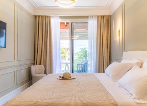 una camera da letto con un letto con un cappello sopra di Ormos Luxury Suites Elia a Ormos Panagias