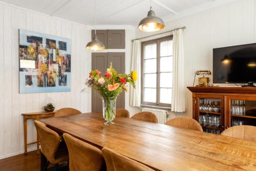a dining room table with a vase of flowers on it at The Eagle - 12 guests - Zwolle in Zwolle