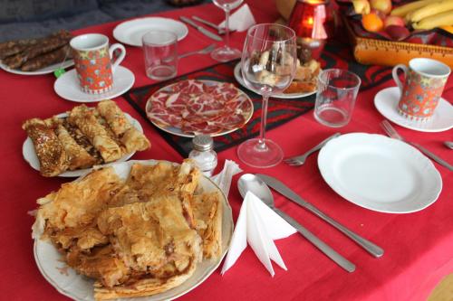 a red table with plates of food and glasses of wine at Rooms Jurca in Postojna