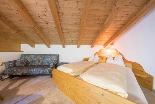 ein Schlafzimmer mit einem Bett und einem Stuhl in einem Zimmer in der Unterkunft Haus Hubertus - Fewo 6 in St. Leonhard in Passeier