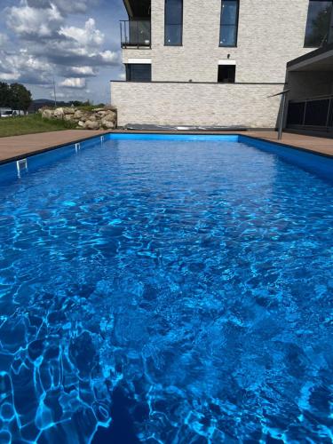 a large blue swimming pool in front of a building at Apartament Krzysztofa Bochusa in Jelenia Góra
