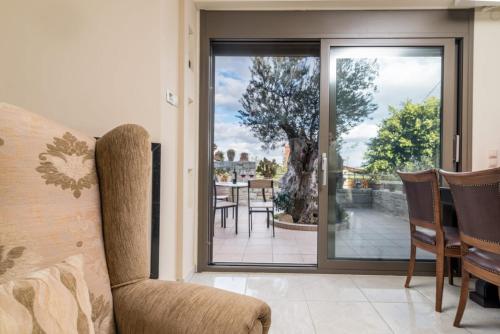 a room with a sliding glass door with a table and chairs at Villa Olive Tree in Pitsidia