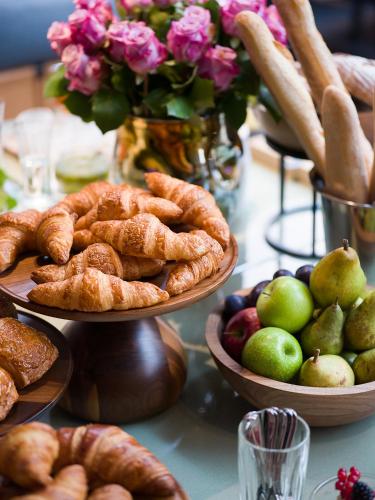 a table topped with plates of pastries and fruit at Maximilian Hotel in Prague