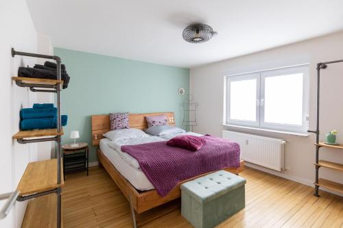 a bedroom with a bed with a purple blanket at Quartier Walzwerk in Püttlingen