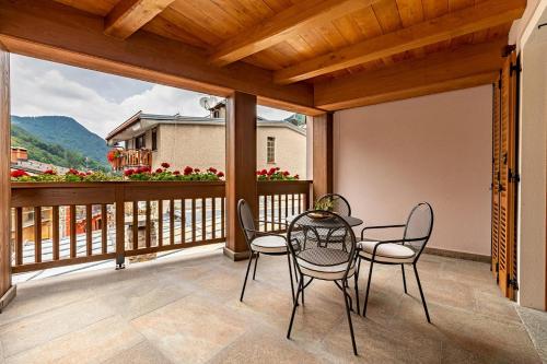 a patio with a table and chairs on a balcony at Fiocco di Neve Relais & SPA in Limone Piemonte