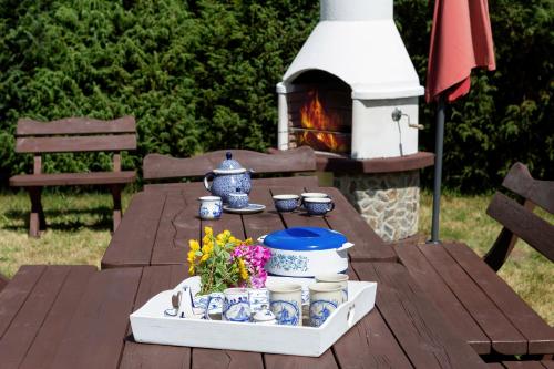 a picnic table with a tray of dishes and a fireplace at Windmill vacation home in Ledzin near Baltic Sea in Niechorze