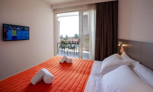 a bedroom with a large bed with towels on it at Residenza Olivo in Garda