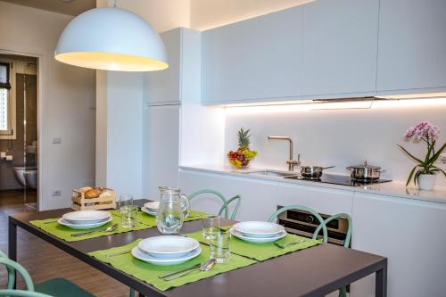a dining room with a table and a kitchen at Residenza Olivo in Garda