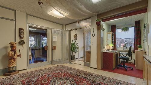 a hallway with an office with a desk and a room with a desk at Hotel Luitpold in Landshut
