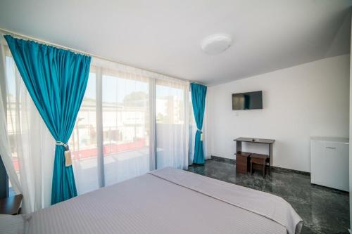 a bedroom with a bed and a large window at Quantum villa in Neptun