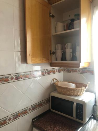un microondas en una cocina con una cesta encima en Cozy apartment by the sea Palangre 17, en Torrevieja