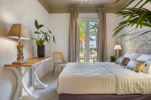 a bedroom with a bed and a desk and a window at Makis Hotel in Skala