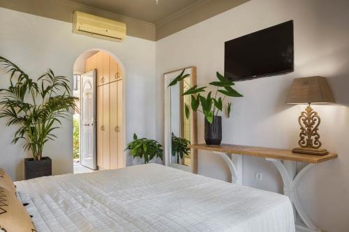 a bedroom with a bed and a flat screen tv at Makis Hotel in Skala Kefalonias
