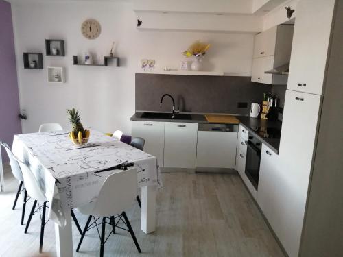 cocina con mesa, mesa blanca y sillas en Apartment Nana, en Supetarska Draga