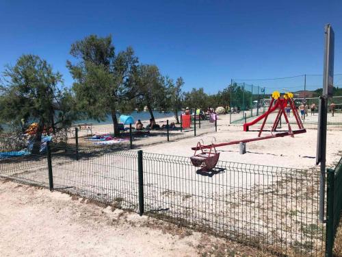 un parque con parque infantil con columpio en Apartments Perla, en Biograd na Moru