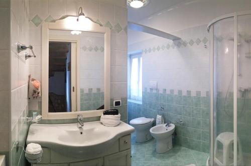 y baño con lavabo, aseo y espejo. en il Roseto holidays, en Castelnuovo del Garda