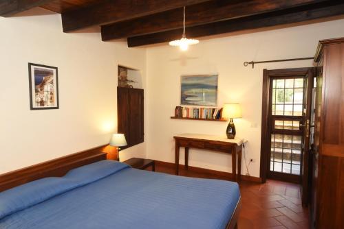 a bedroom with a blue bed and a table at Dépendance Viburni in Alghero