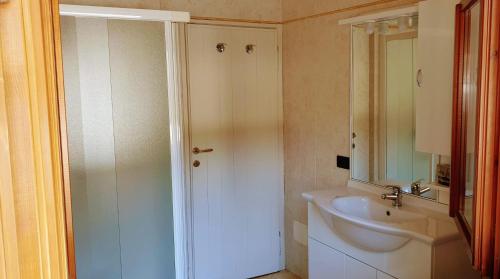 a white bathroom with a sink and a shower at Residence Villalsole in San Felice del Benaco