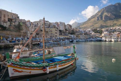 a boat sitting in the water in a harbor at Hotel La Piazzetta in Castellammare del Golfo