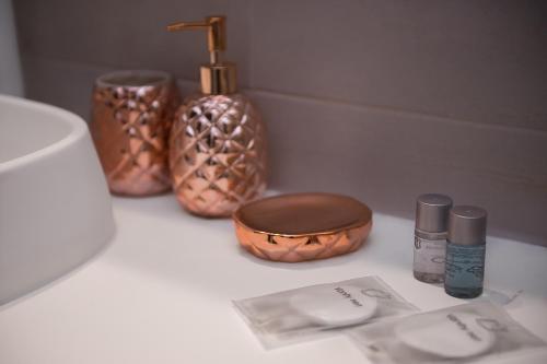 a bathroom counter with a sink and some cosmetics at Boutique 23 in Douăzeci şi Trei August