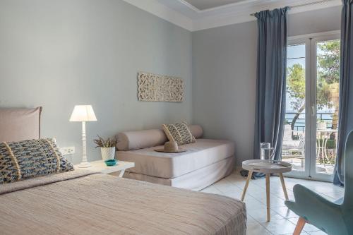 a bedroom with a bed and a couch at Makis Hotel in Skala Kefalonias