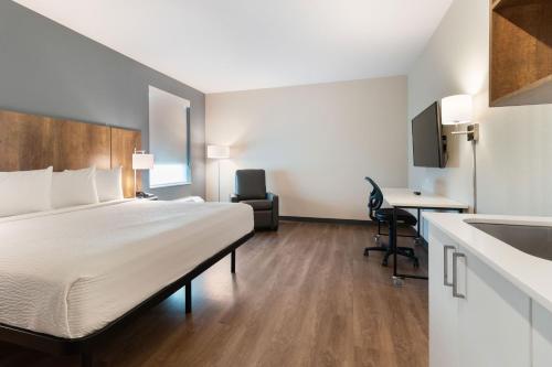 a hotel room with a bed and a sink at Extended Stay America Premier Suites - Port Charlotte - I-75 in Port Charlotte